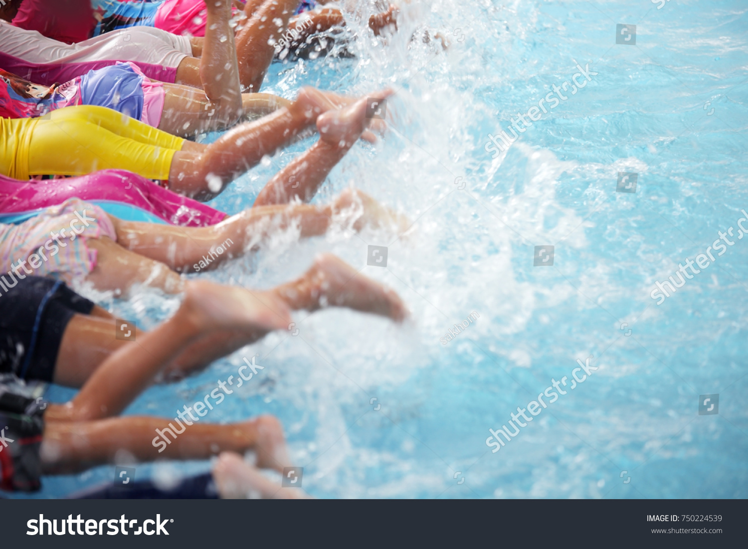 group of children at swimming pool class learning to swim #750224539