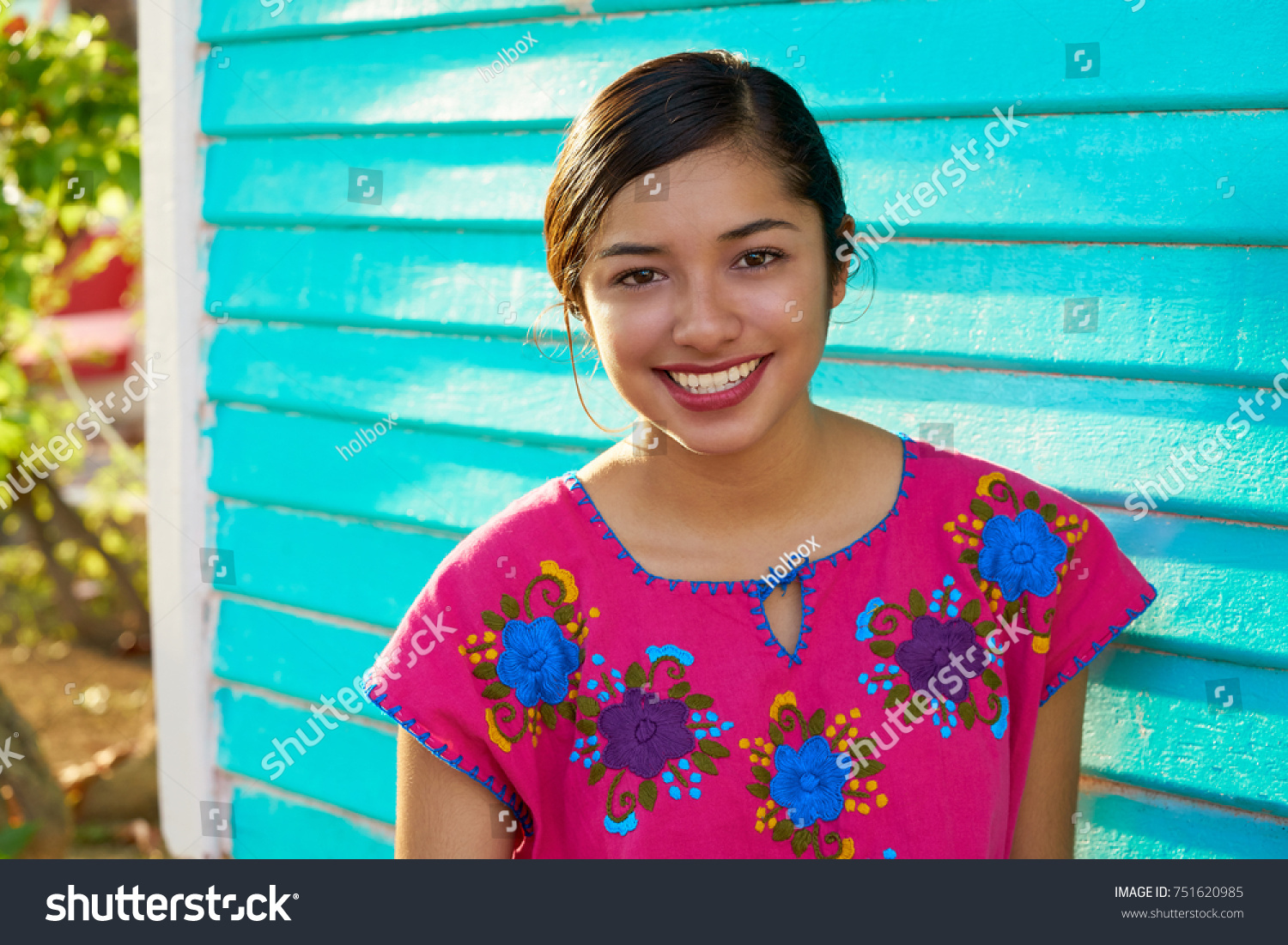 Mexican latin woman with mayan dress smiling in turquoise wall #751620985