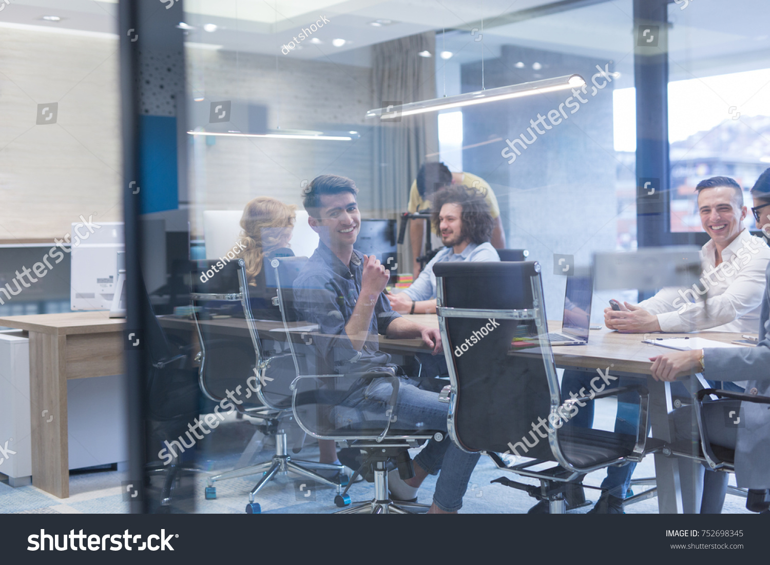 Group of a young business people discussing business plan at modern startup office building #752698345