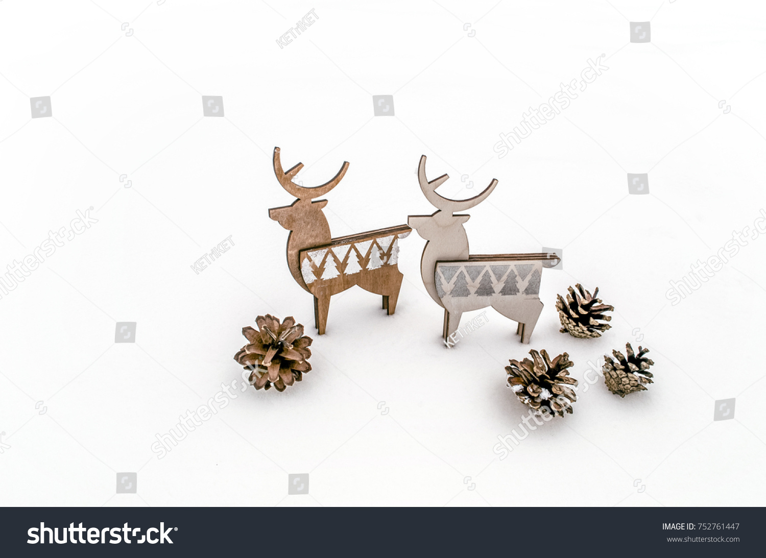 A pair of deer plywood with cones on white snow. Christmas background for presentation of work or text. Copy space. #752761447