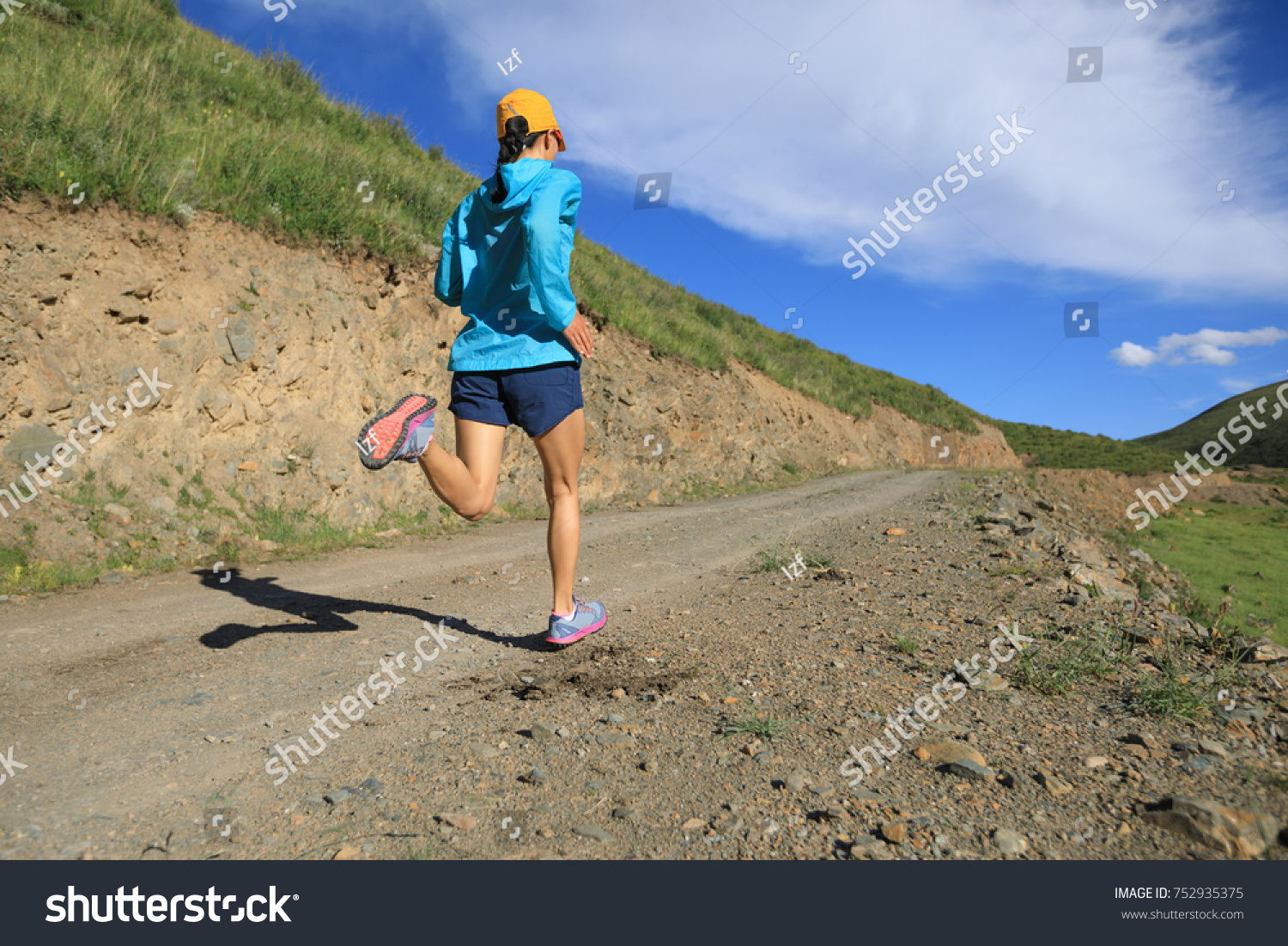 young fitness woman runner running on mountain trail #752935375