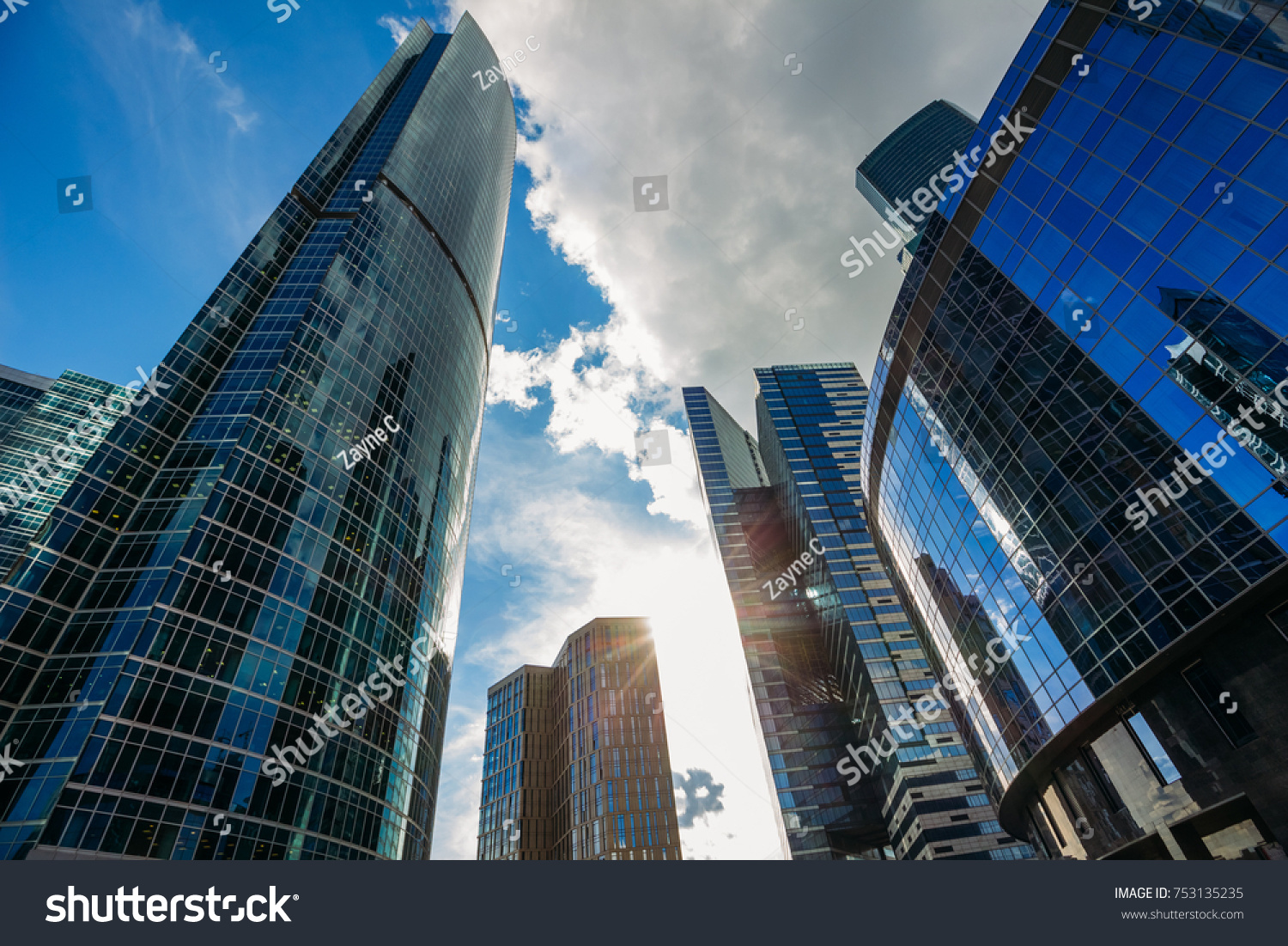 Moscow-city business center against the blue sky with the sun before sunset #753135235