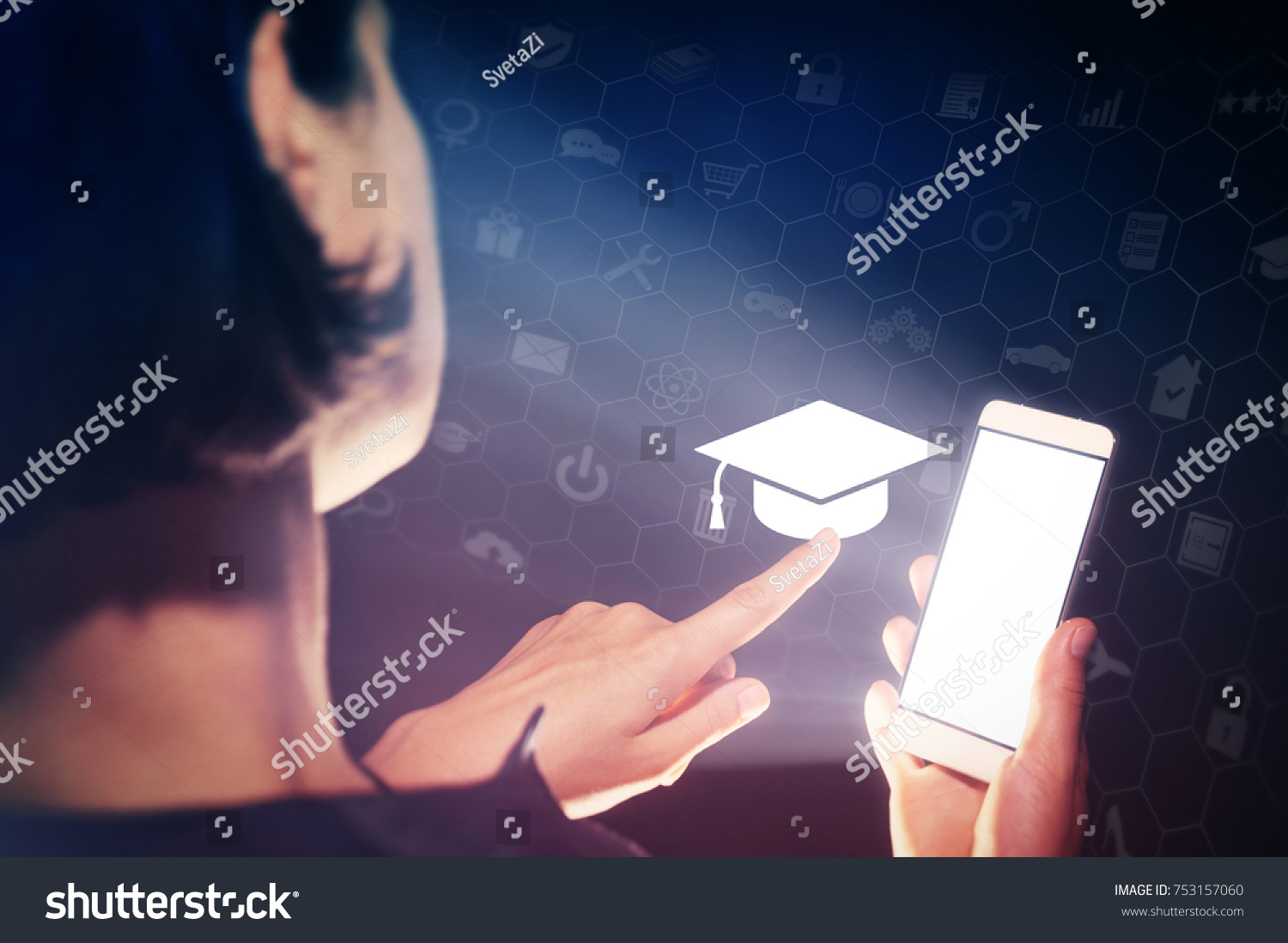 Image of a girl with a smartphone in hands. She presses on the graduation hat cap icon. Concept of online education, choose of career. #753157060