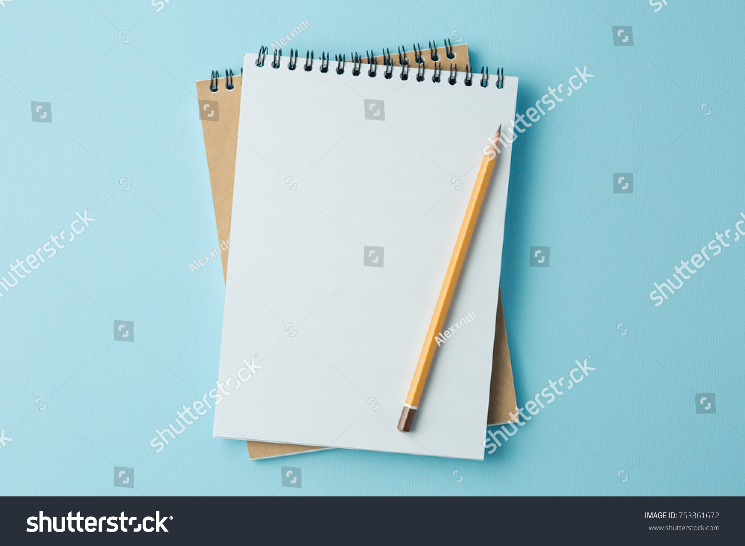 school notebook on a blue background, spiral notepad on a table #753361672