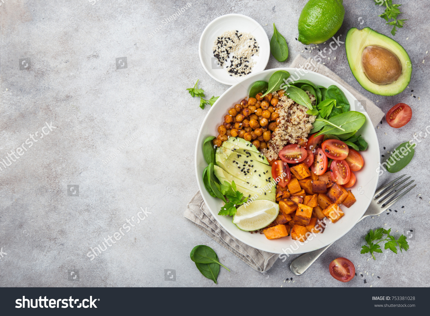 healhty vegan lunch bowl. Avocado, quinoa, sweet potato, tomato, spinach and chickpeas vegetables salad. Top view #753381028