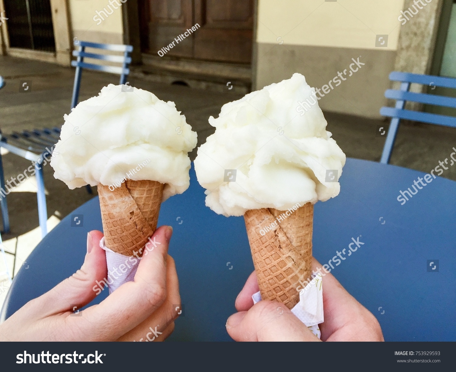 Two lemon sorbet ice creams set against blue street furniture of an ice cream parlor in Turin #753929593