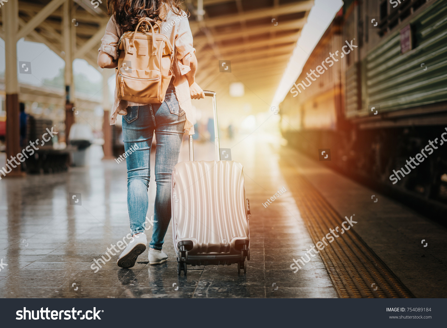 Woman traveler tourist walking with luggage at train station. Active and travel lifestyle concept #754089184