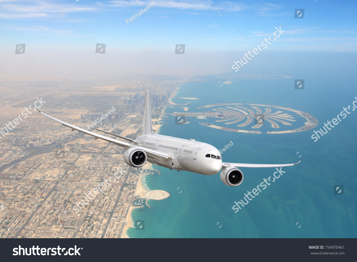 White civil twin-engine passenger airliner flying above Dubai city and coastline. #754970461