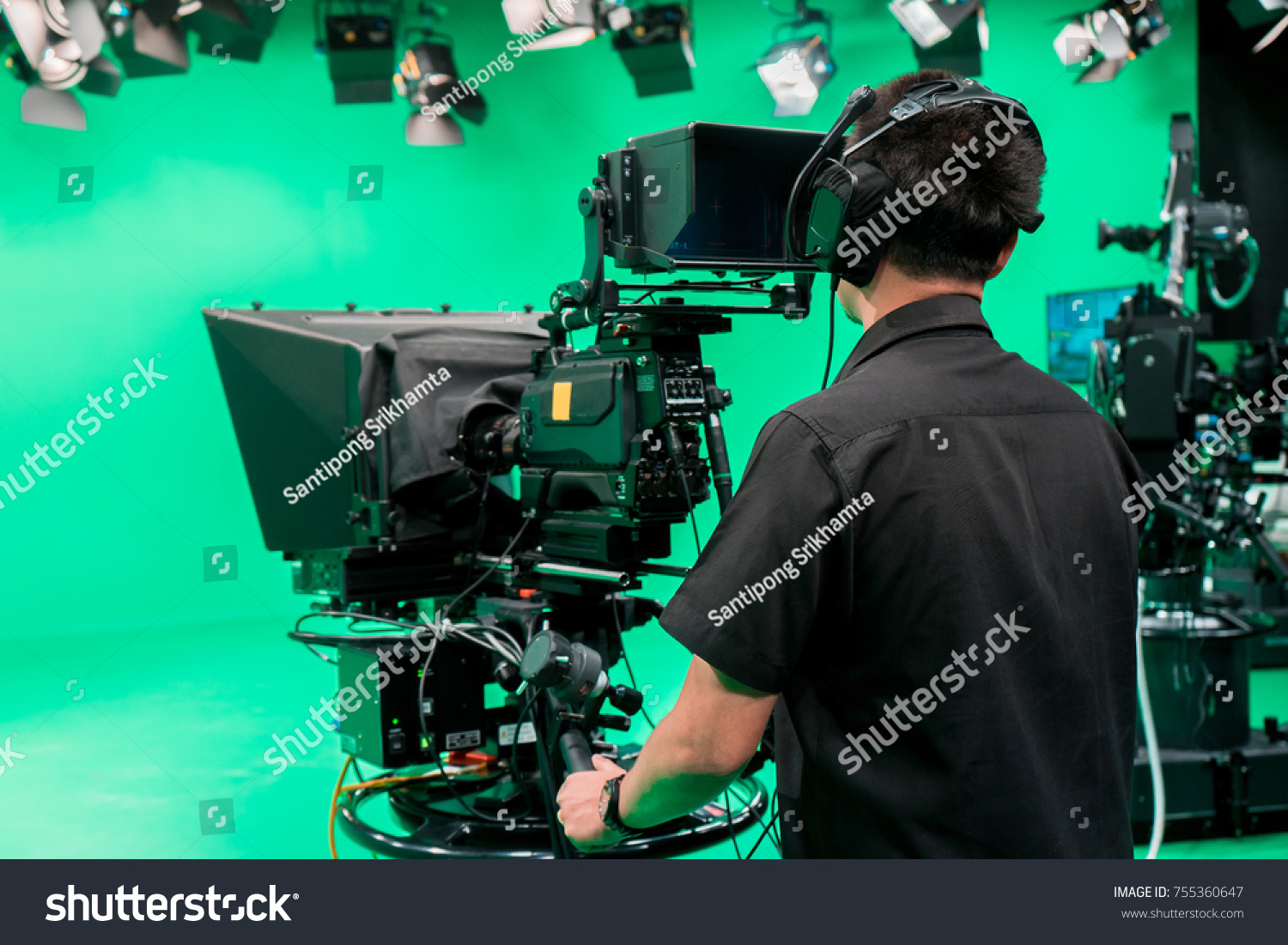 Cameraman taking a broadcast camera  in broadcast television virtual green screen studio room. #755360647