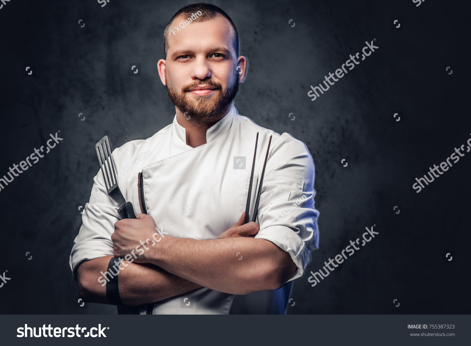 Chef cook holds a knife over dark grey background. #755387323