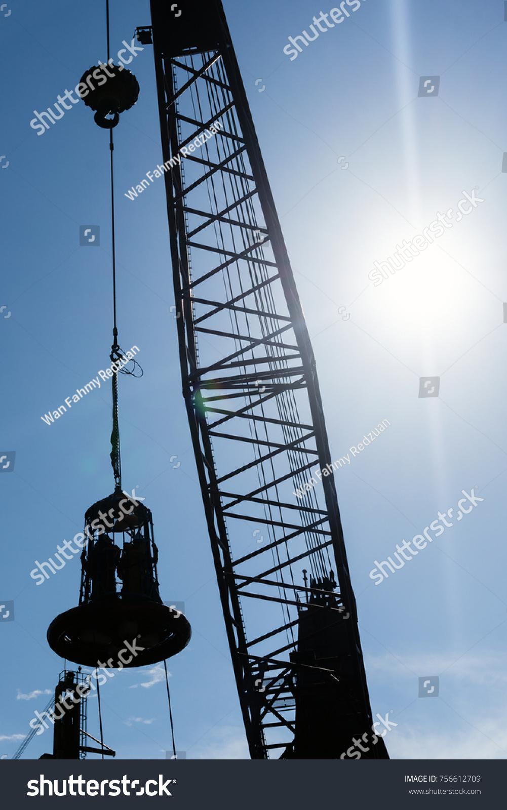 Personal transfer basket being lifted by a construction barge’s crane to transfer offshore crew at oilfield #756612709