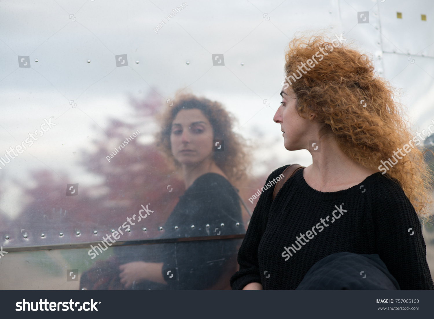 woman taking a passing look at reflection in side of American style diner like a huge mirror
 #757065160