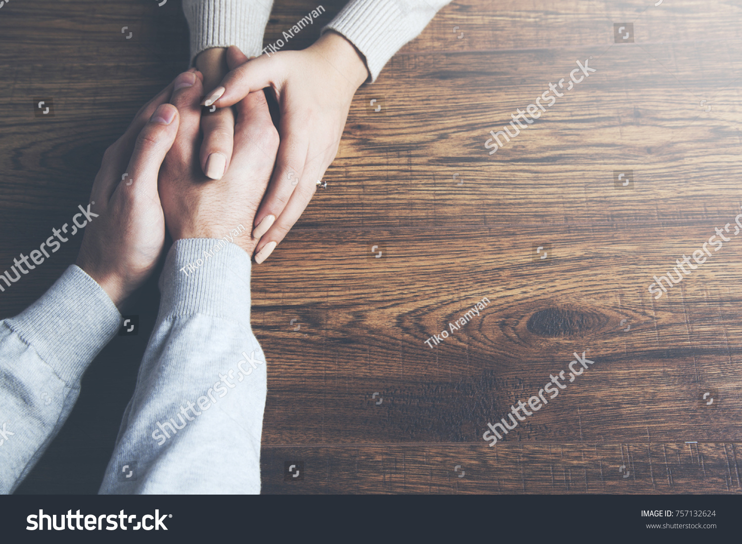 Closeup on two young lovers holding hands at a table #757132624
