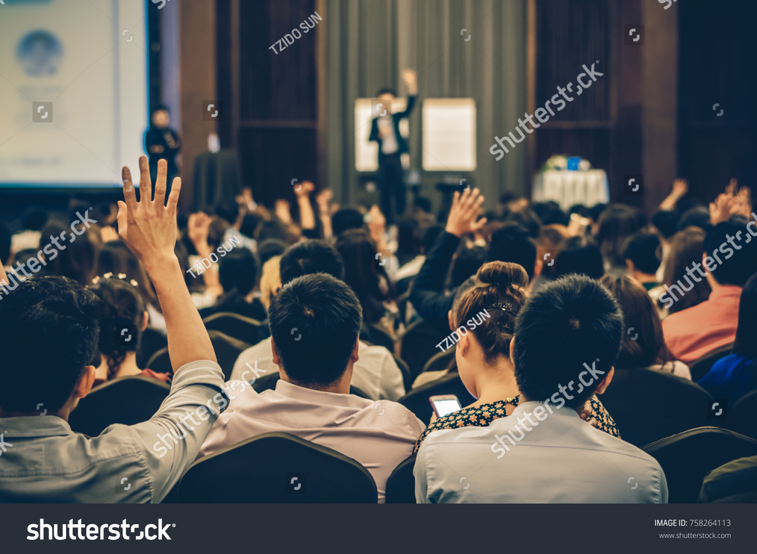 Speaker on the stage with Rear view of Audience in the conference hall or seminar meeting, business and education concept #758264113