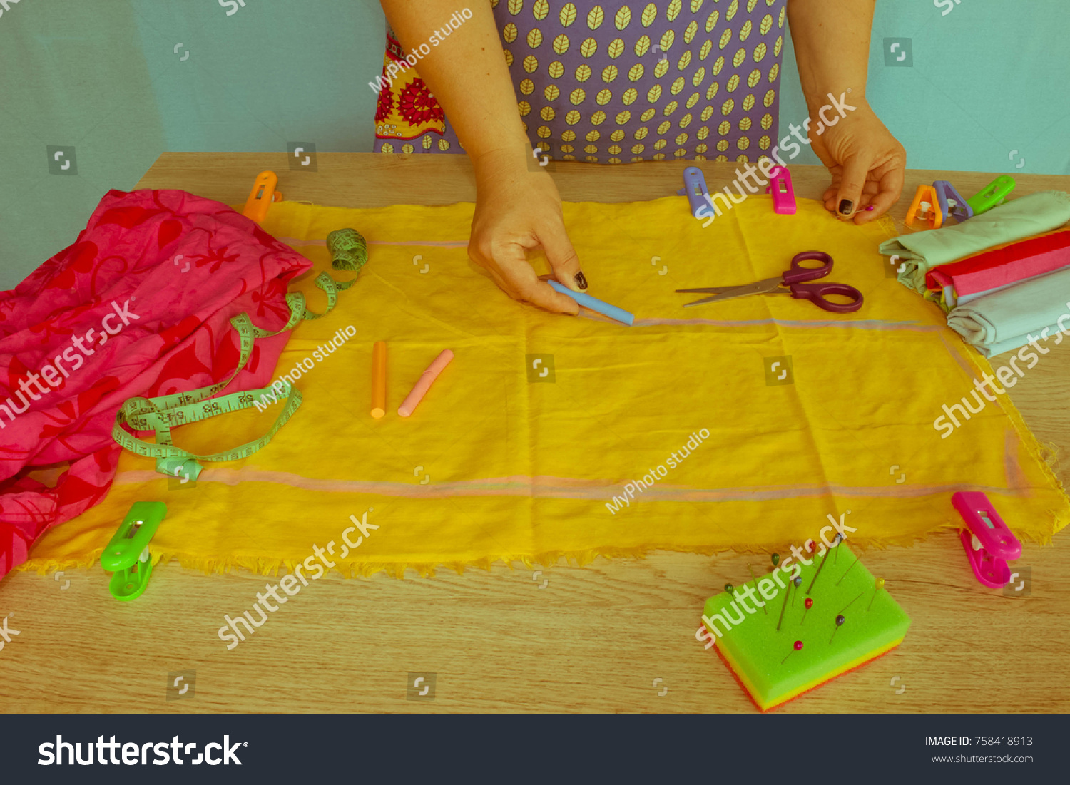 closeup of woman hands sewing yellow cloth outdoors. Woman's Hand Sewing Quilt #758418913