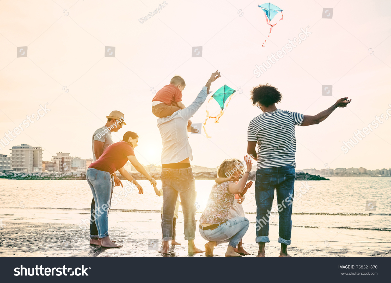 Happy familes flying with kite and having fun on the beach - Parents playing with children outdoor - Travel,love and holidays concept - Main focus on right woman - Warm filter #758521870