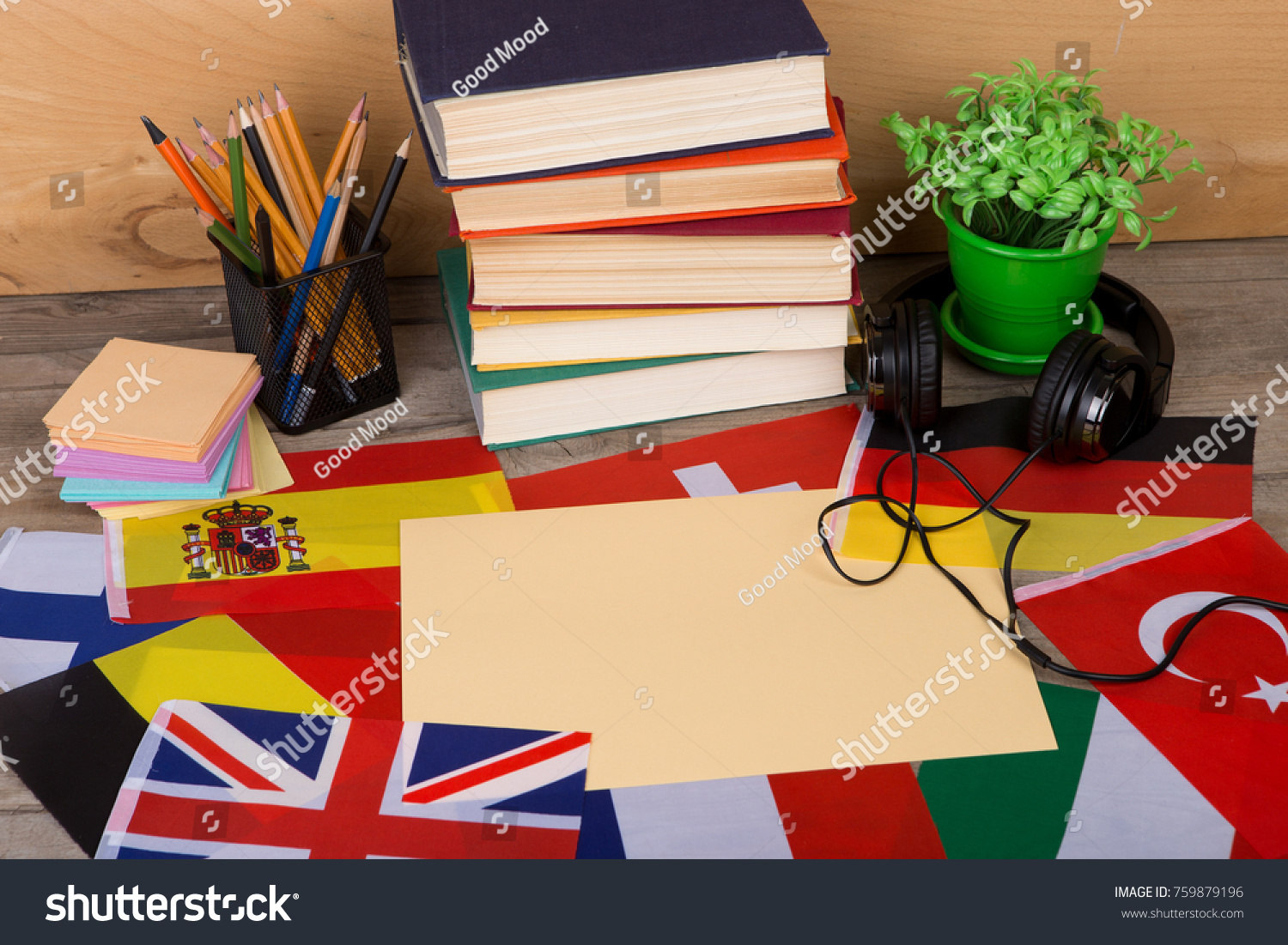 Learning languages concept - blank paper, flags, books, headphones, pencils on wooden background #759879196