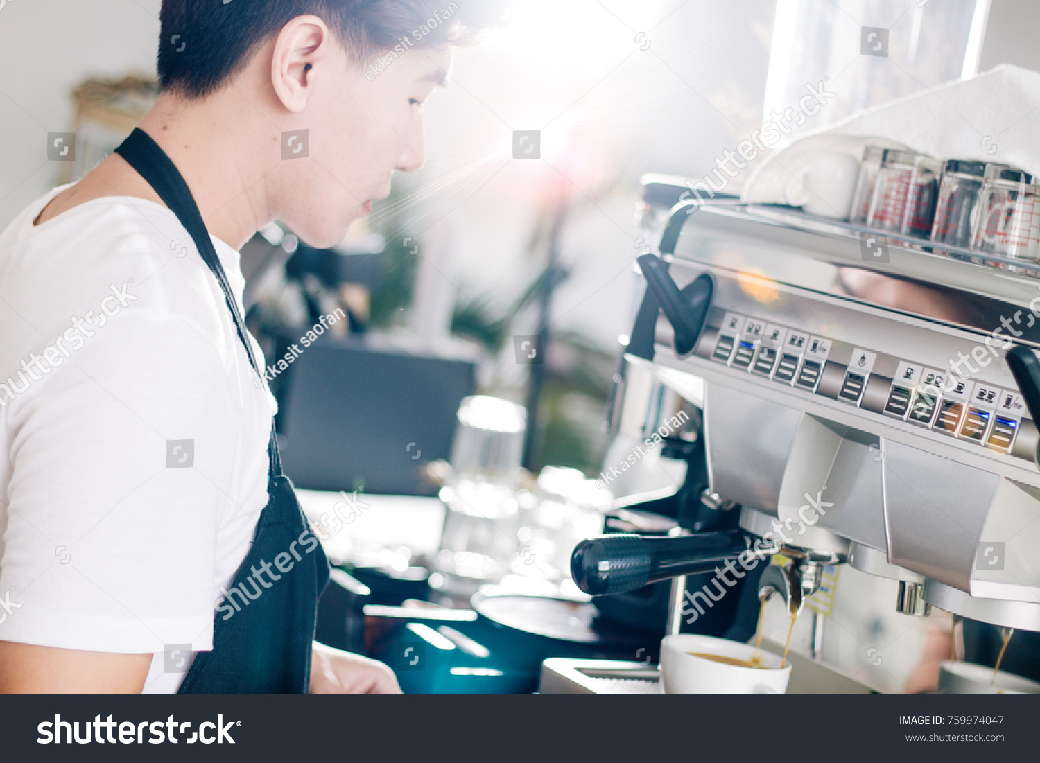 portrait  of young waiter making cup of coffee at coffee shop. #759974047