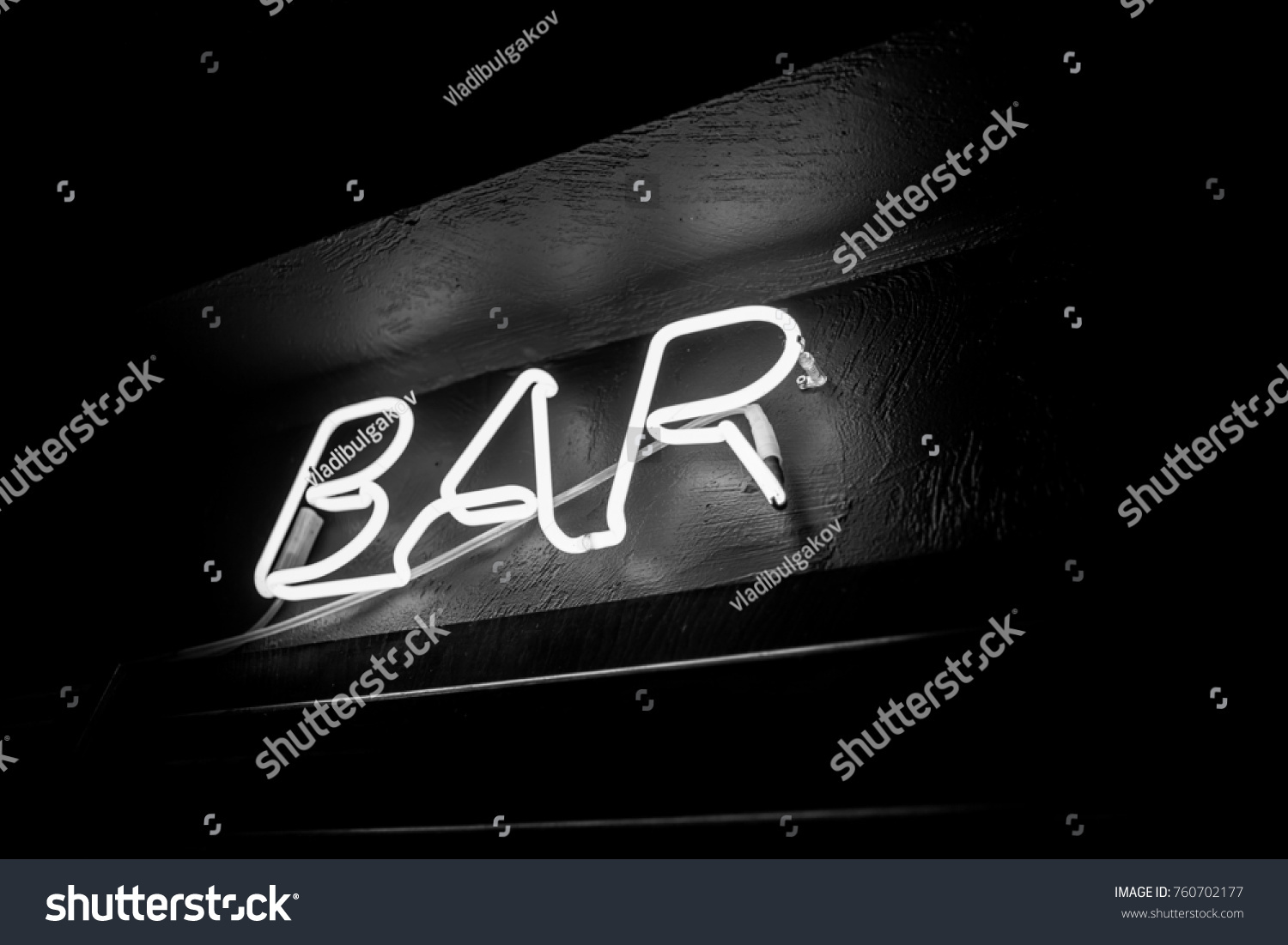 Neon inscription BAR on the wall. Neon inscription BAR in different colors. Multicolored neon inscription BAR on dark background. Black and white photo #760702177