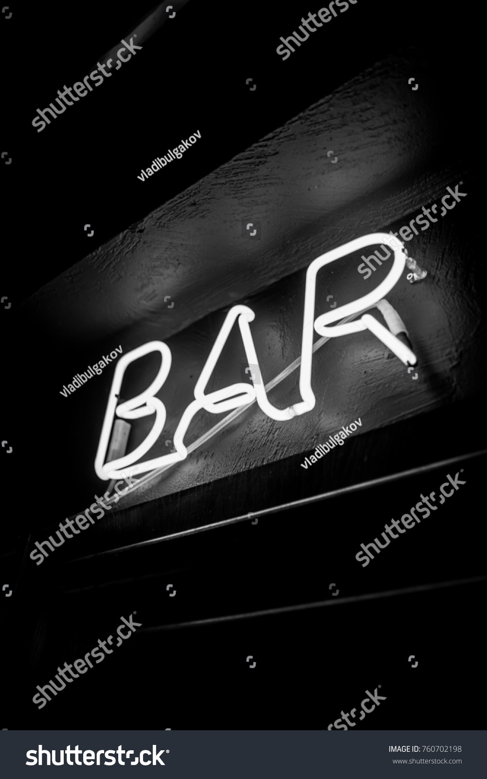 Neon inscription BAR on the wall. Neon inscription BAR in different colors. Multicolored neon inscription BAR on dark background. Black and white photo #760702198