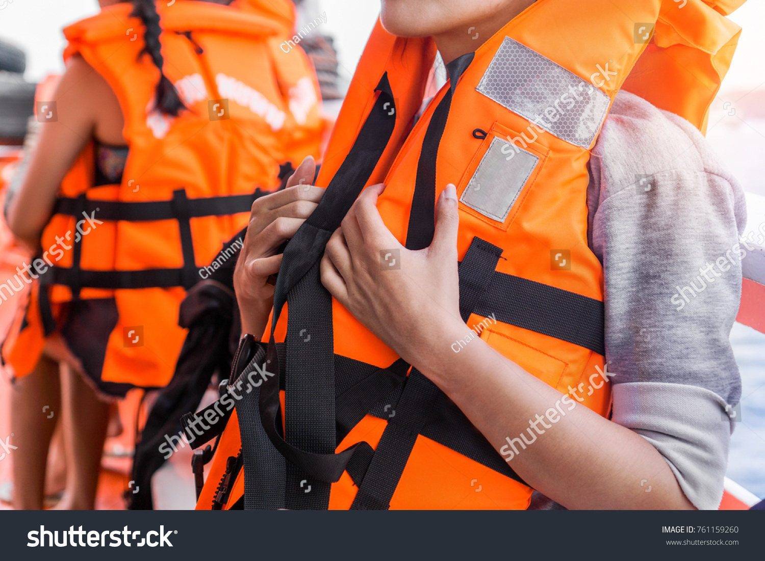 Asian female in life jacket with other people near sea on ship #761159260