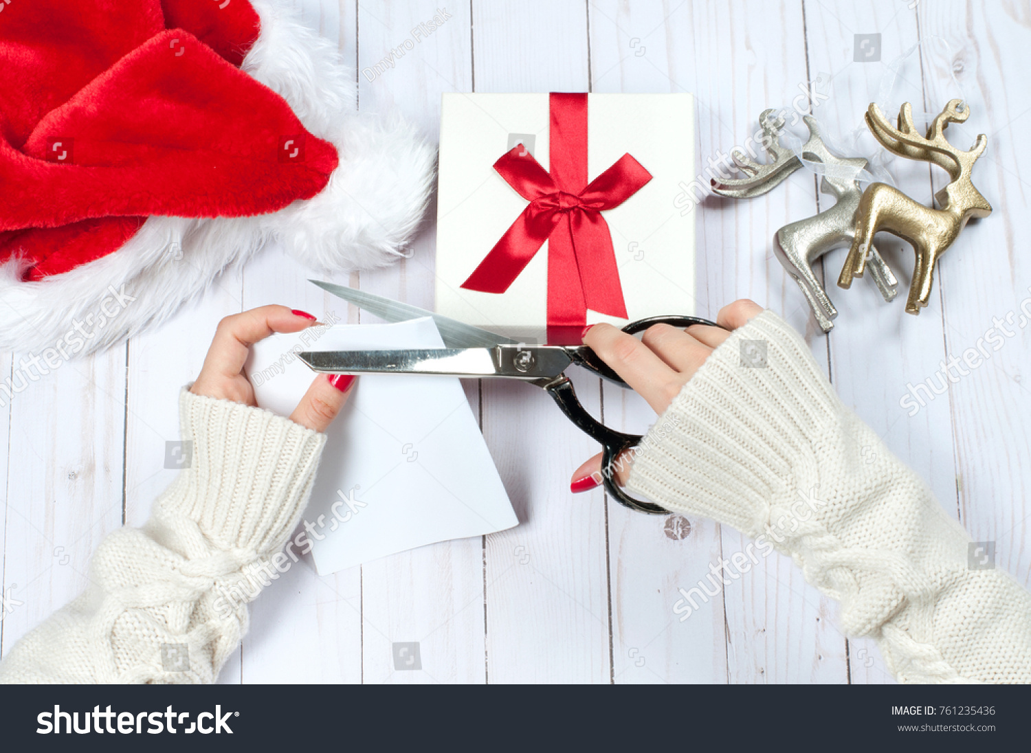 Christmas and New Year gift. Woman holding Christmas presents on a wooden table background #761235436
