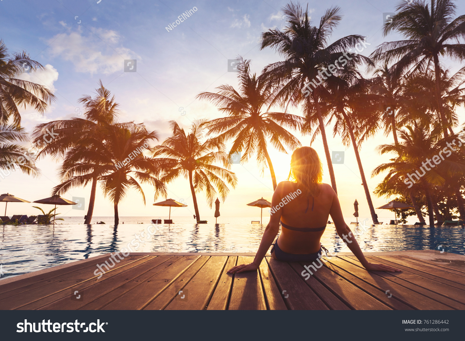 Woman enjoying vacation holidays at luxurious beachfront hotel resort with swimming pool and tropical lansdcape near the beach #761286442