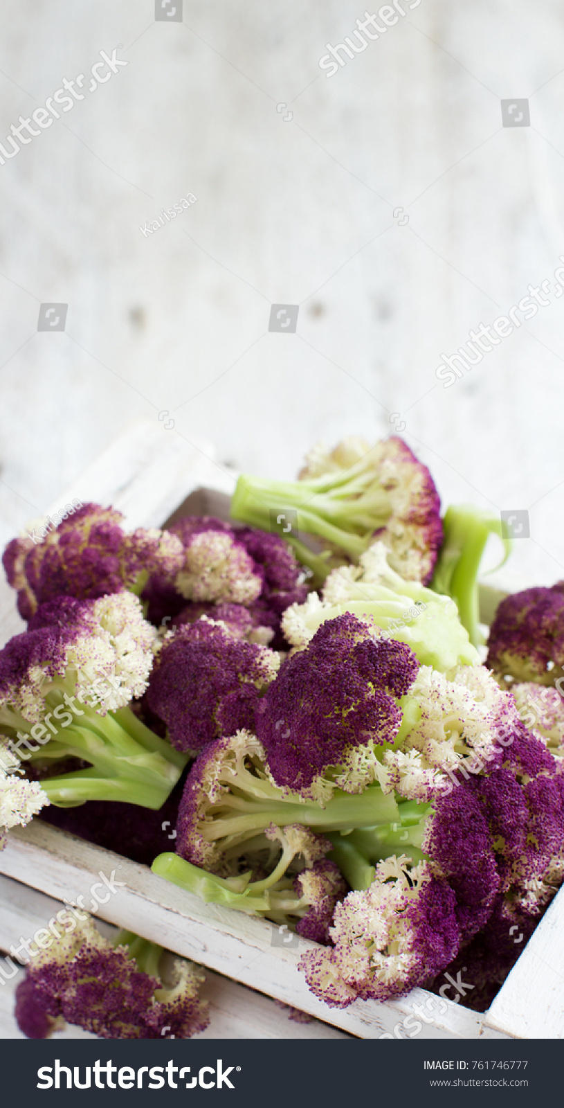 Fresh raw purple cauliflower on a wooden board close up #761746777