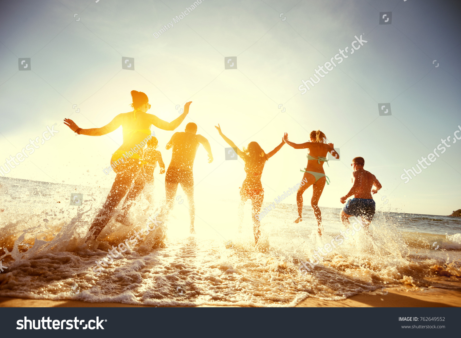 Big group of people having fun at sunset beach #762649552