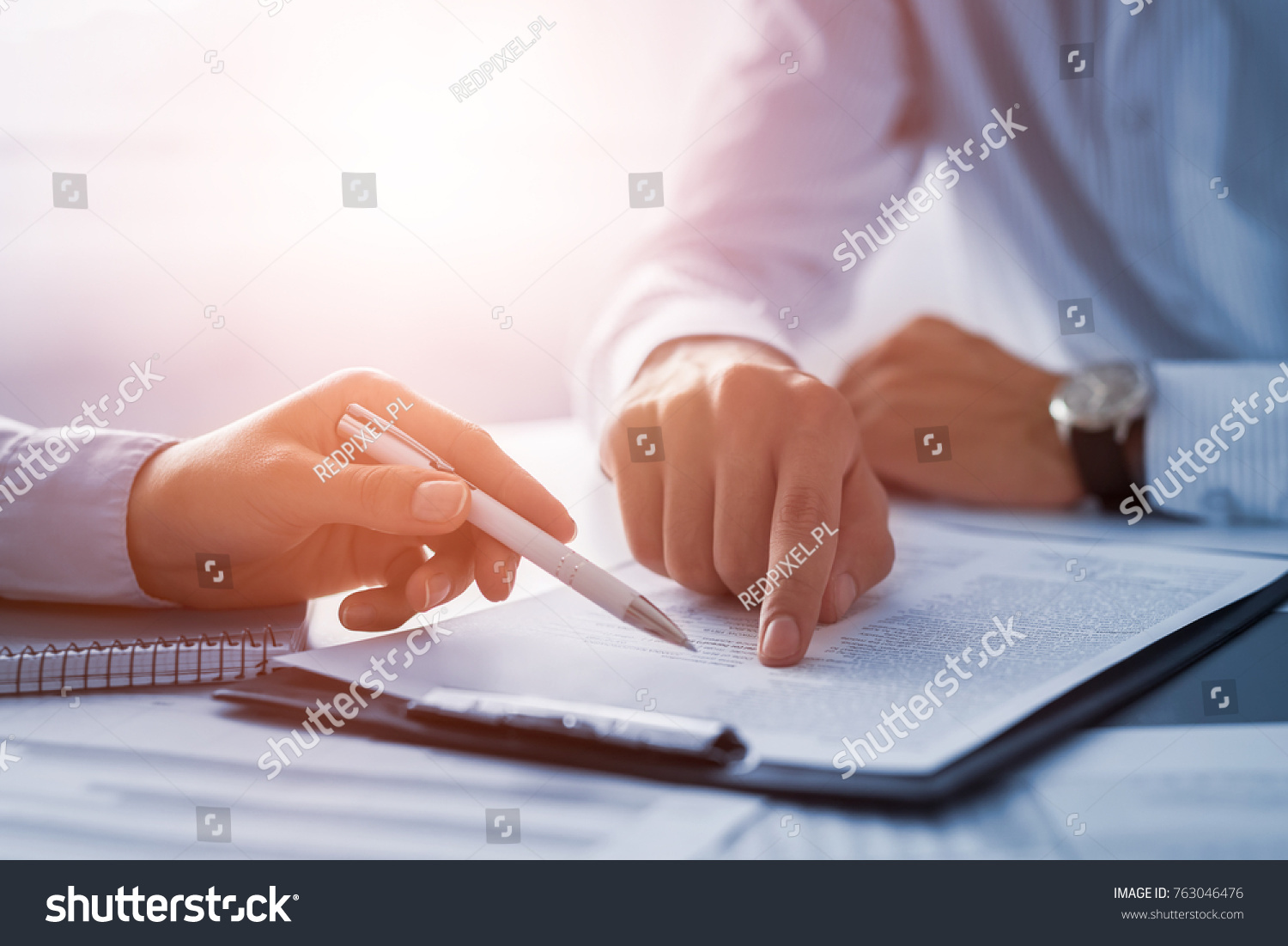 Business people negotiating a contract. Human hands working with documents at desk and signing contract. #763046476