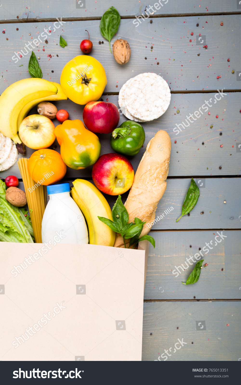 Grocery shopping concept. Different food in paper bag on wooden background.  Flat lay #765013351