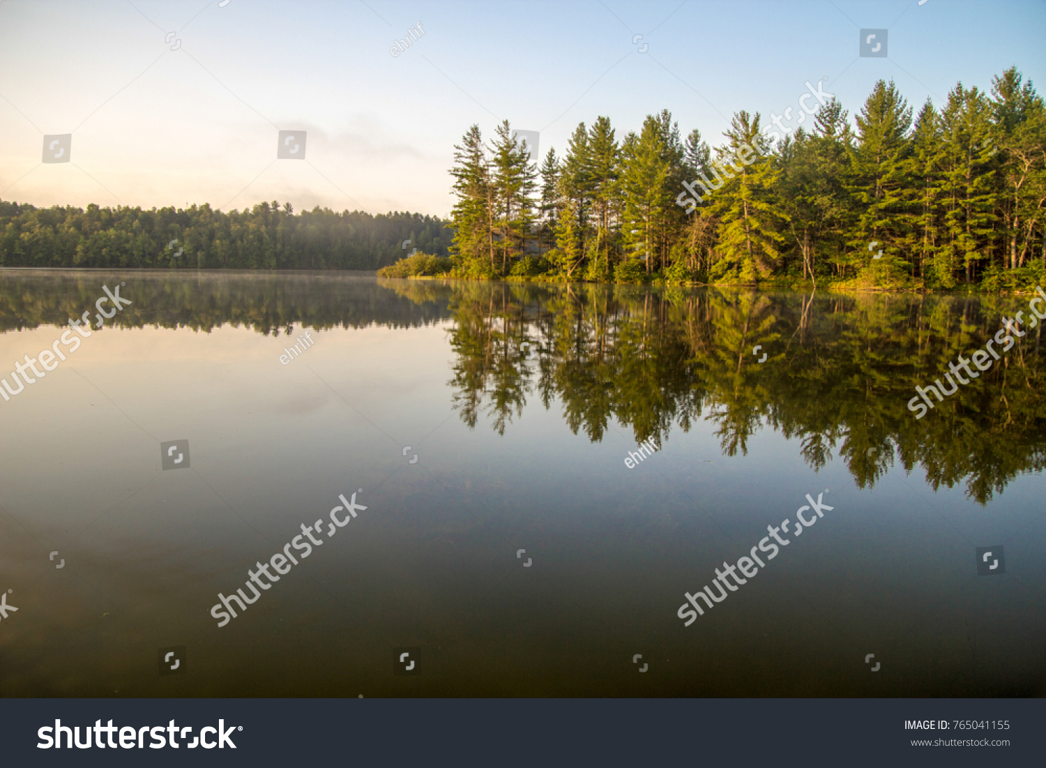 Northern Michigan Wilderness Lake. Wilderness lake with forest reflections in the water and copy space in the foreground in Mio, Michigan.
 #765041155