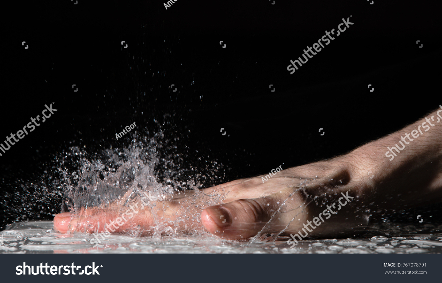 Splash of water drops after clap hand on the table #767078791