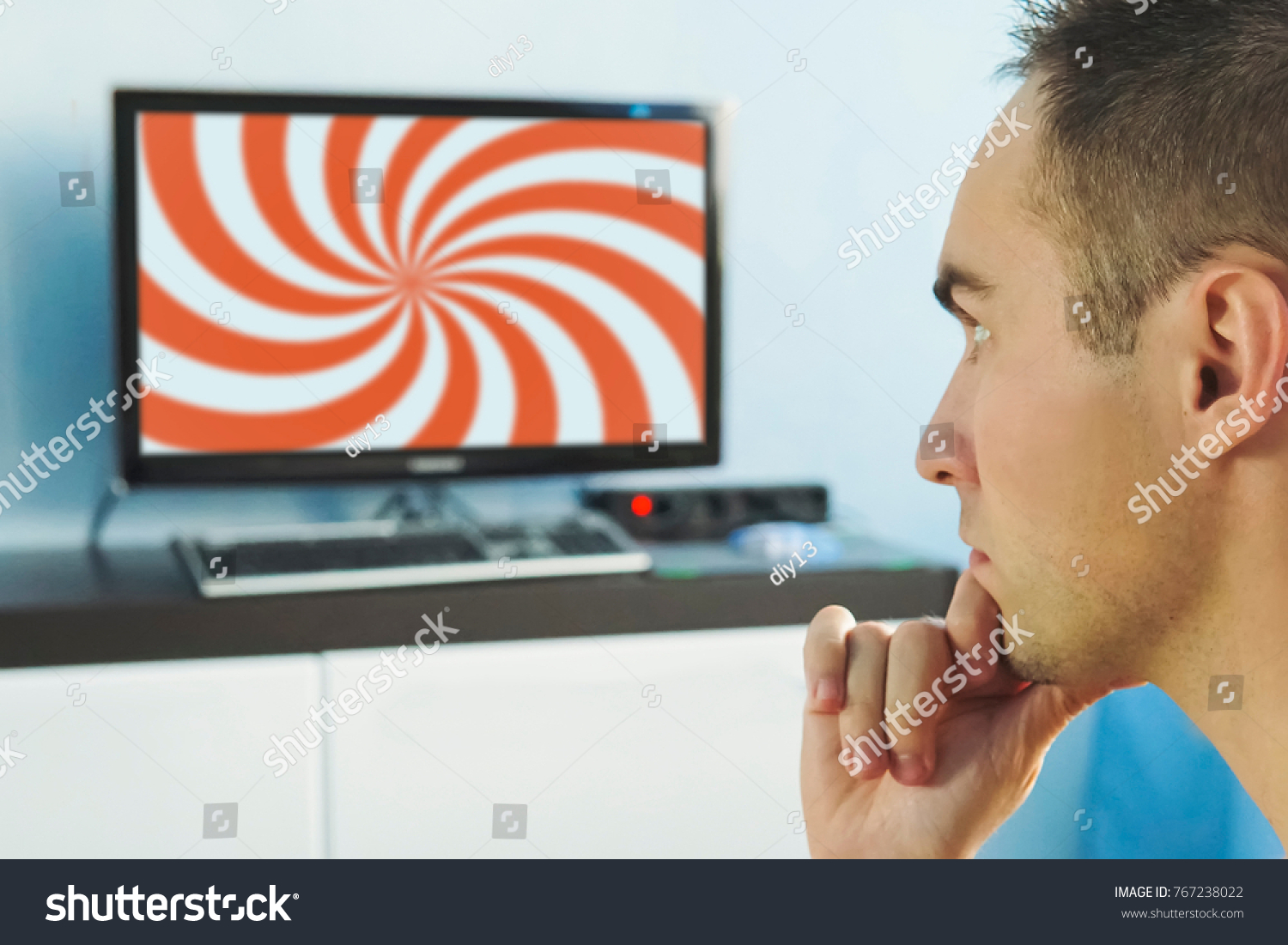 Brainwashed elderly man. hypnotic spiral on the screen of the TV. The young man hypnotized by false information on the monitor screen. False news on the Internet. viewer in front of the TV. #767238022