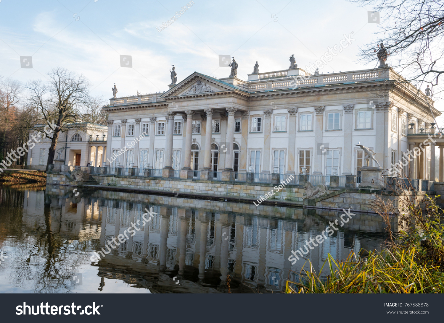 Historic palace by the lake during sunny fall day, Lazienki Krolewskie Warszawa Poland #767588878