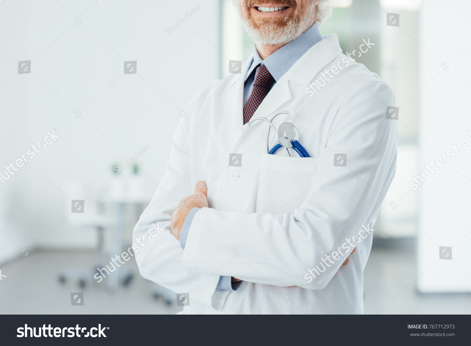 Confident doctor at hospital posing with folded arms and smiling at camera #767712973