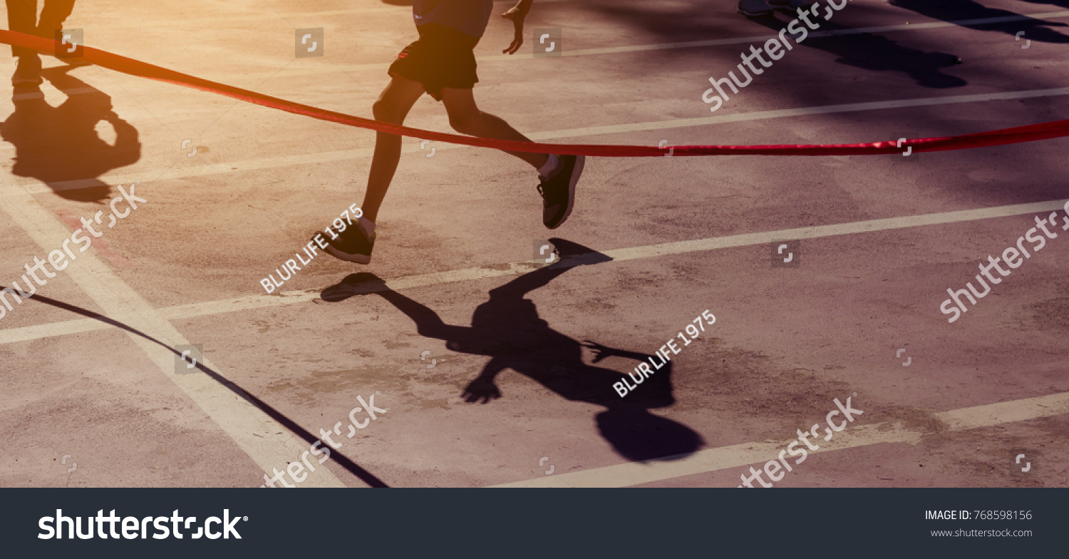 silhouette image of ribbon at finish line with kids winner crossing it.(vintahe tone) #768598156