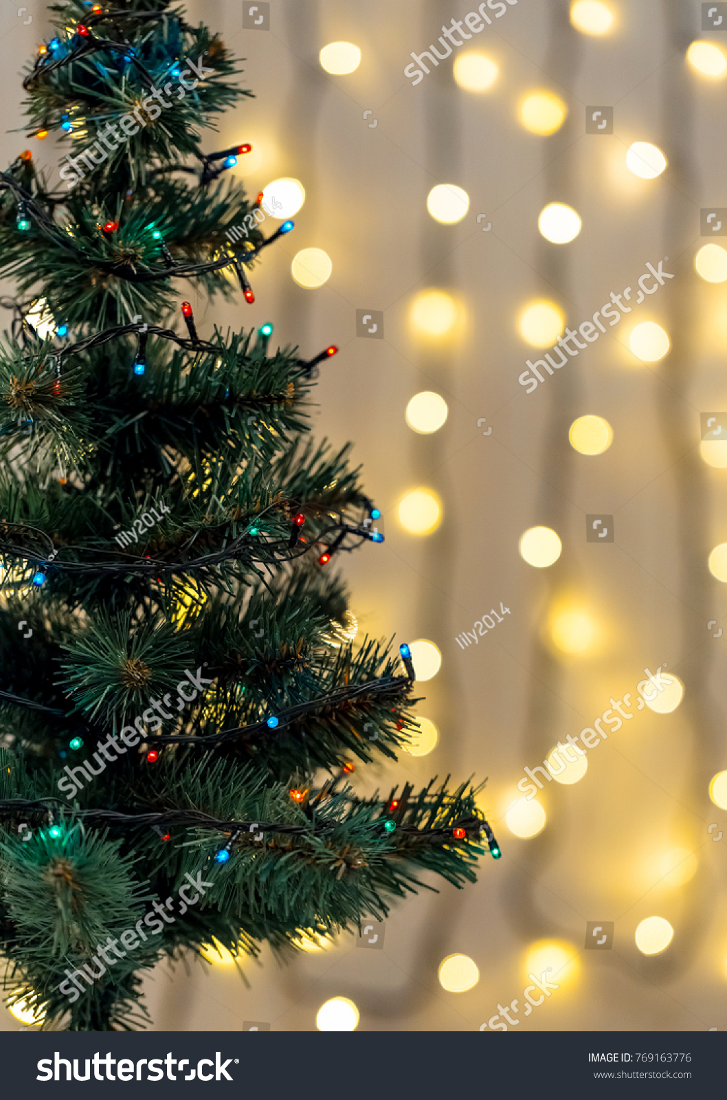 Gold Christmas background of de-focused lights garland with decorated tree #769163776