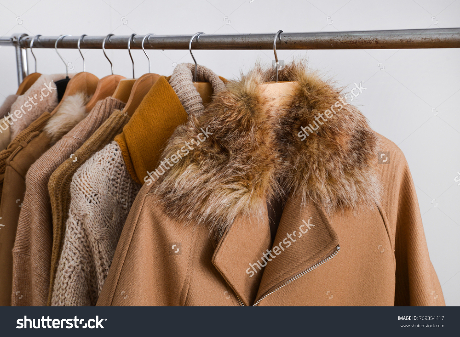 Row of women leather coat and jacket with sweater on hangers isolated
 #769354417
