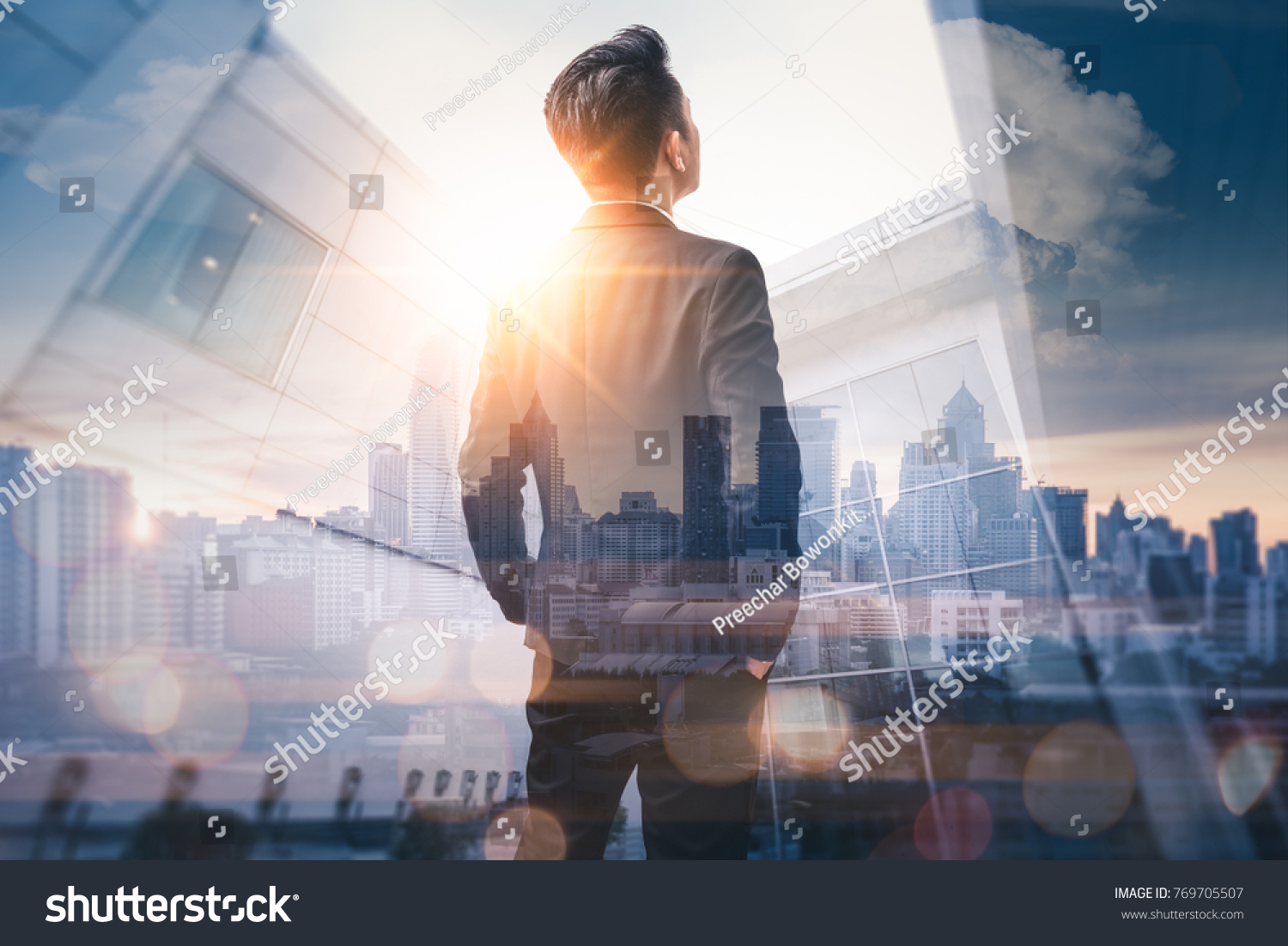 The double exposure image of the business man standing back during sunrise overlay with cityscape image. The concept of modern life, business, city life and internet of things. #769705507