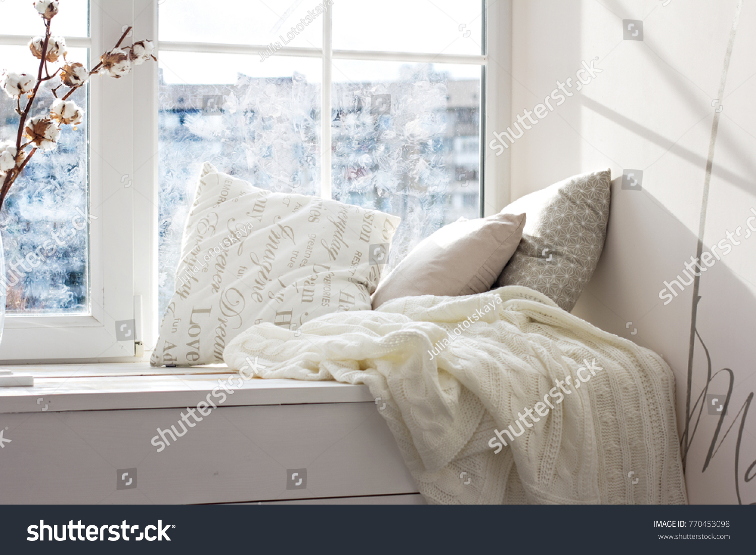 cushions and a knitted plaid on the windowsill. A cozy winter window sill.  #770453098