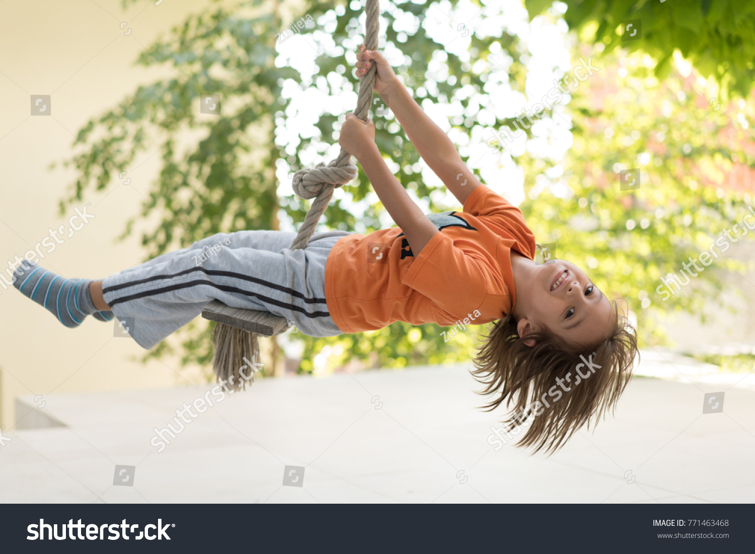 Cute happy little boy upside down on swing rope #771463468