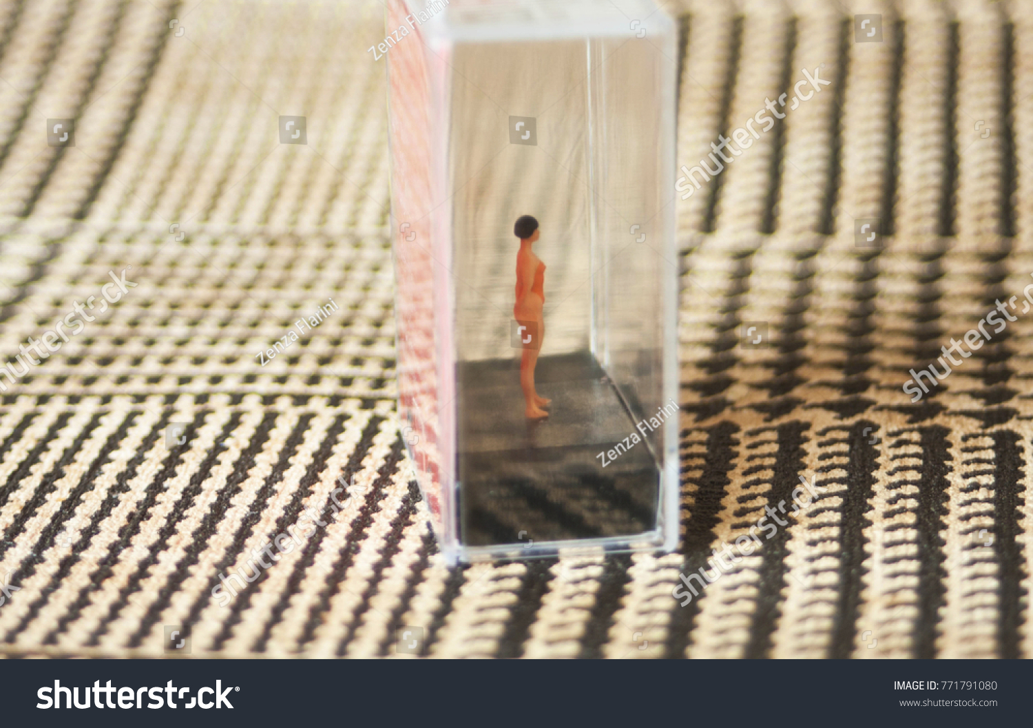 Tiny woman or girl in a glass box. Body issues concept or unrealistic standards of beauty. Depicted in miniature with Instagram filters and soft focus. Eating disorders, body dysmorphia.  #771791080