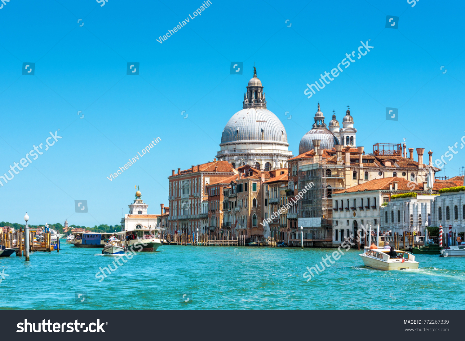 Basilica of Santa Maria della Salute on the Grand Canal in Venice, Italy. Grand Canal is one of main travel attractions of Venice. Historical buildings and landscape of Venice. Water trip in Venice. #772267339