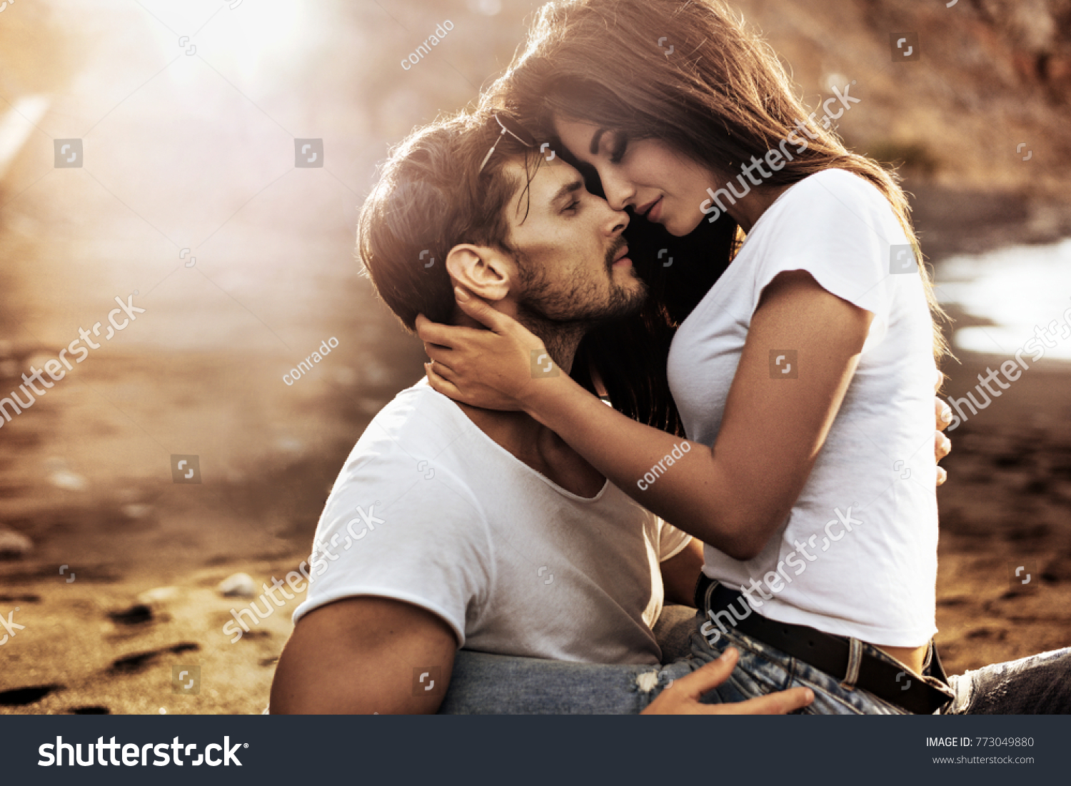 Handsome man hugging his woman on a beach #773049880