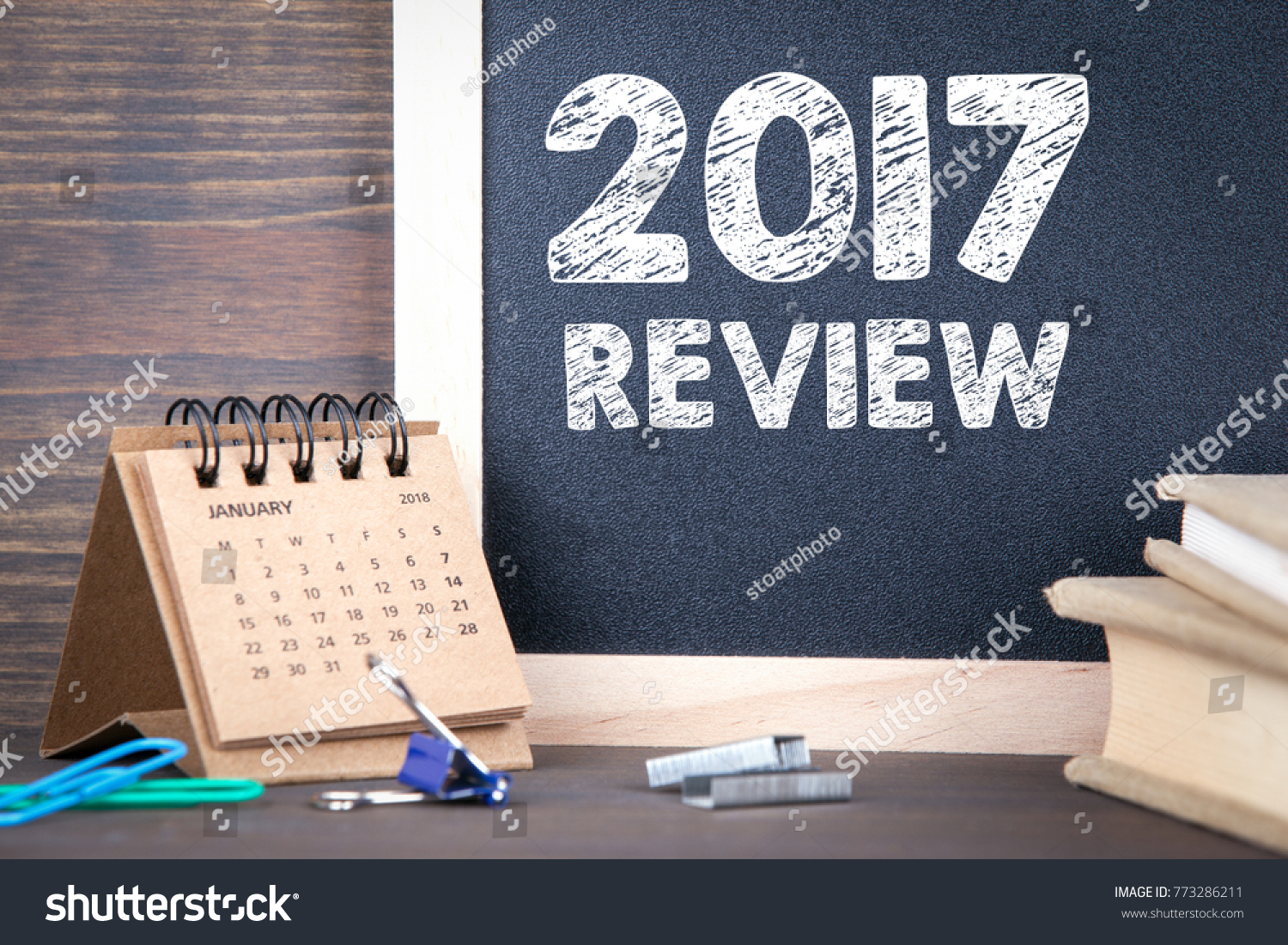 2017 review. paper calendar and chalkboard on a wooden table #773286211