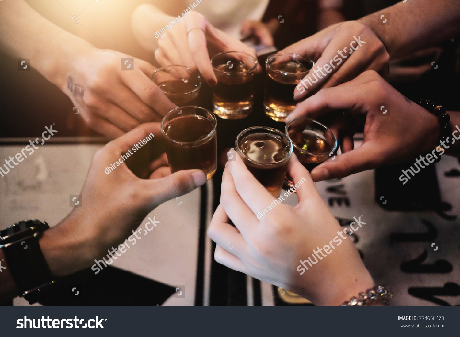 Cheers clinking of friends with bourbon whisky drink in party night after work on colorful background #774650470