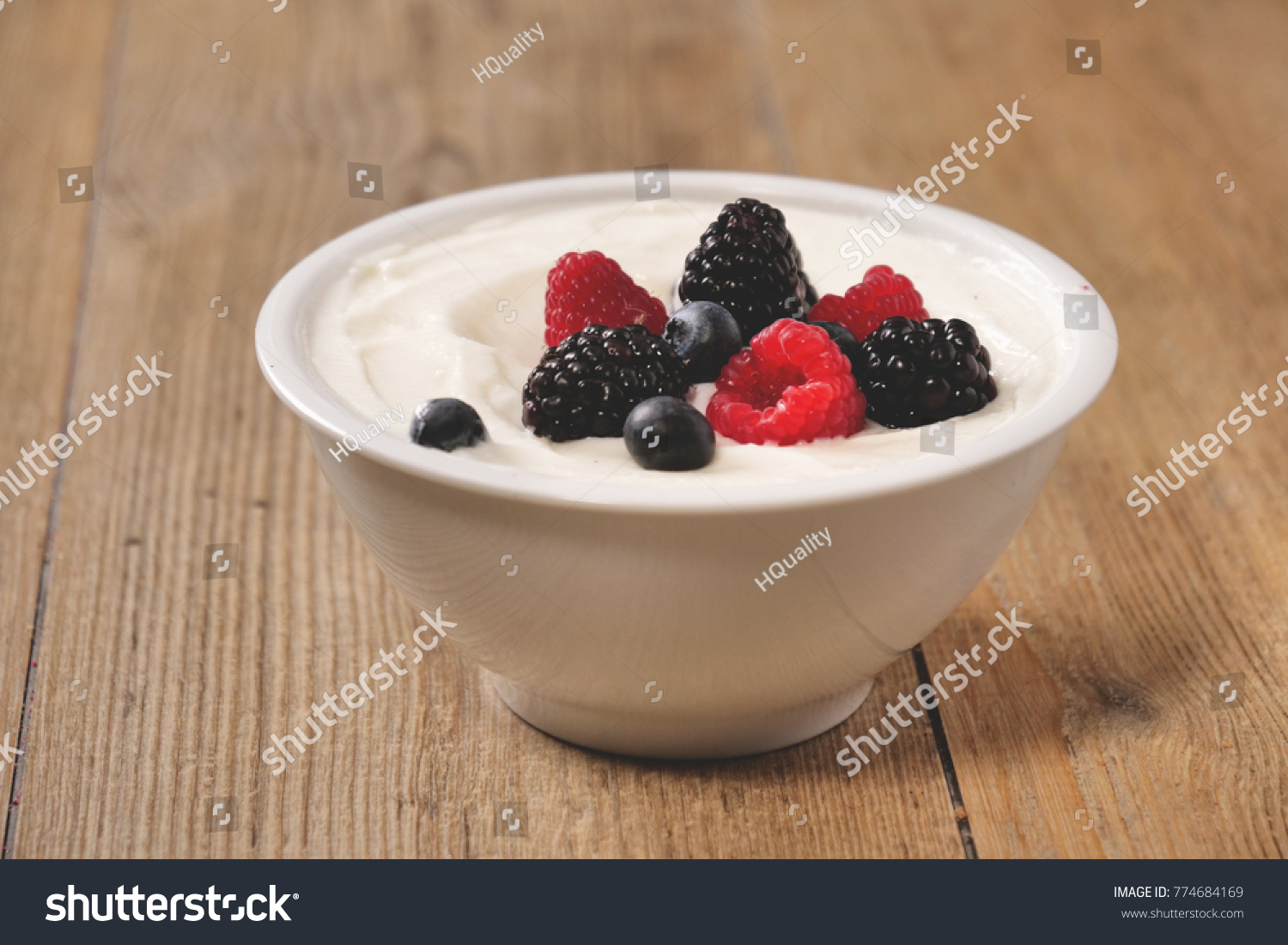 Composition of a typical genuine breakfast made with yogurt, blueberries, raspberries, blackberries, muesli. Concept of: fitness, diet, wellness and breakfasts. #774684169