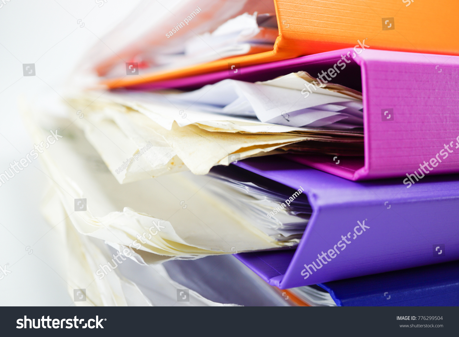 File Folder Binder stack of multi color on table in office. #776299504