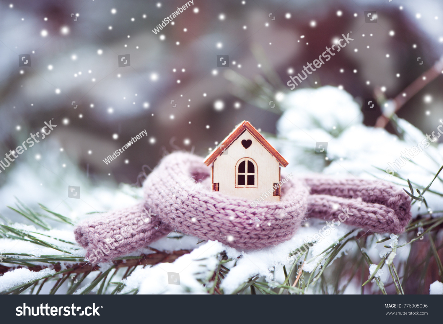 Christmas Toy house is wrapped in a warm scarf, it's snowing.on a natural natural background of a real fir in the snow, toned. Concept of winter, Christmas, new year,
 warm, cozy, loving, protecting  #776905096
